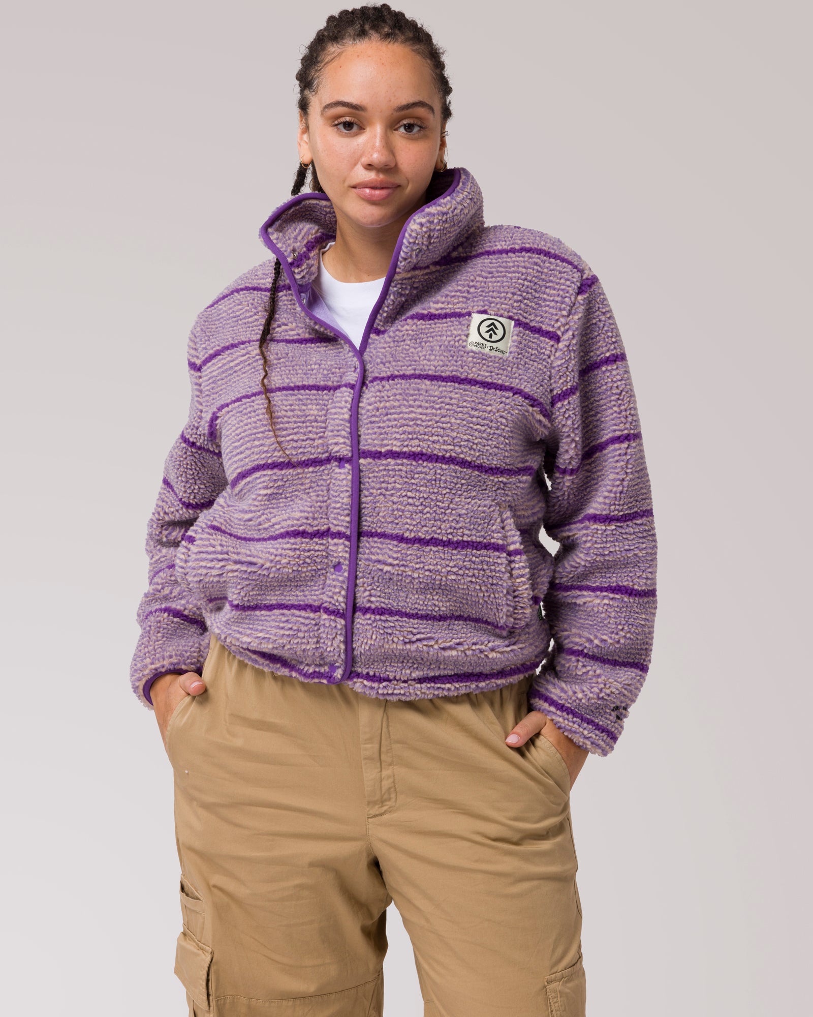 Steggy - Teal fleece jacket with appliquéd purple stegosauruses. Chunky, easy zipper top and deep pockets.